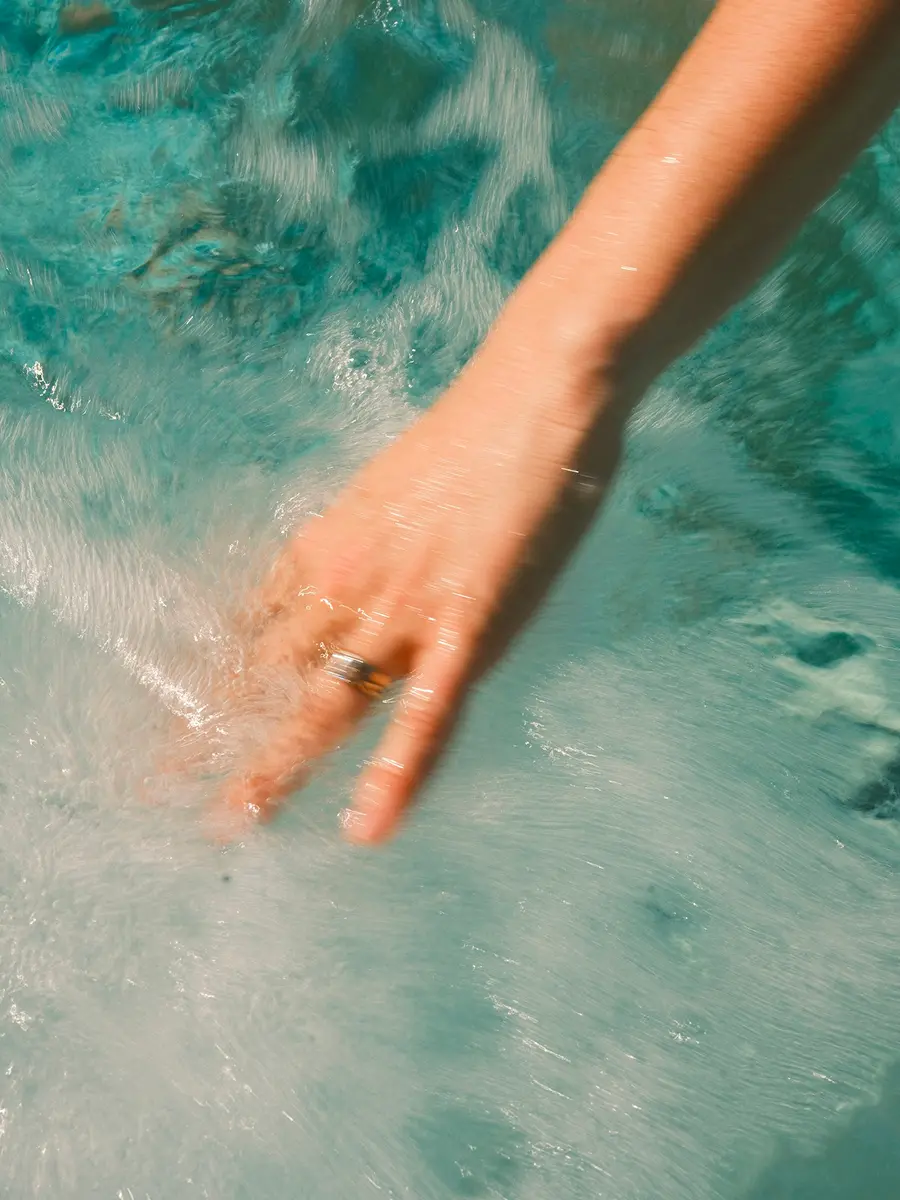 Рука торкається води під час гідромасажу — відчуття спокою та відновлення